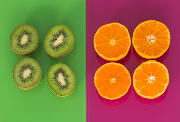 kiwi and orange fruits on green-purple glass background
