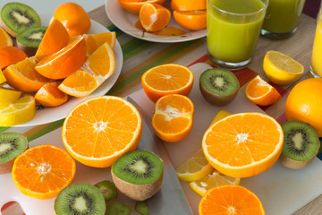 kitchen table set with various types of fruit and juices.