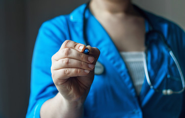 doctor in blue uniform holds the pen in the lens