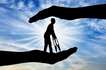 Silhouette of a disabled man with crutches in the hands of help