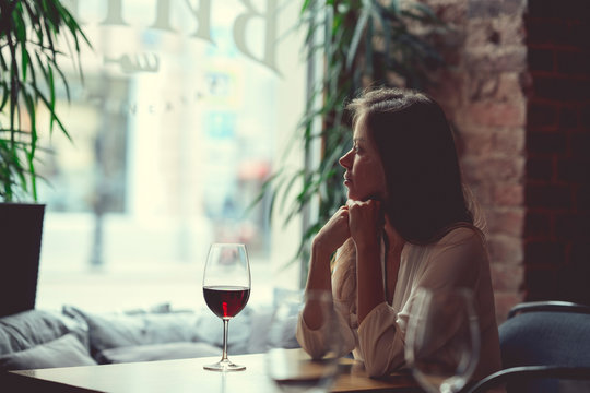 Young attractive girl with a glass of red wine