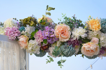 Decorative garland of artificial flowers - roses, hydrangeas and chrysanthemums.