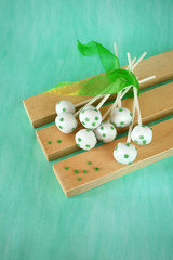 White chocolate cake pops with green stars on wooden boards