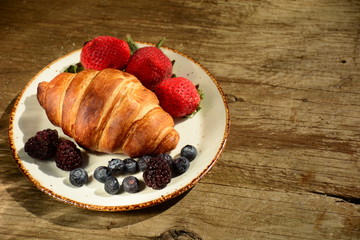 The freshly baked croissants for breakfast with berries and green tea 