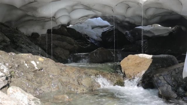 Global warming. Melting of snow cover in mountains. Stream at spring