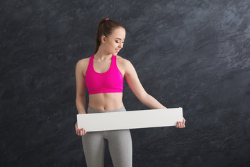 Young sporty woman with blank white paper