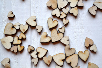 Decorative wooden hearts on a white desk. Love background.