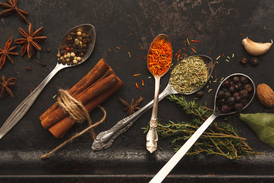 Plenty of herbs and spices on dark old table
