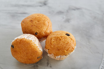 Tasty muffins arranged in pattern on light textured background, close-up, shallow depth of field, selective focus.