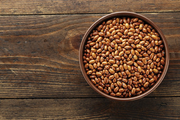 brown beans in a plate on a wooden background