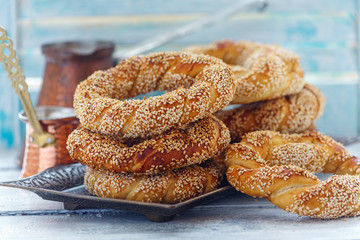 Turkish Simit bagels with sesame seeds on a bronze tray close up.