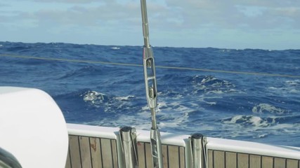 Slow motion view of Atlantic with long waves in sunny afternoon from stern of yacht