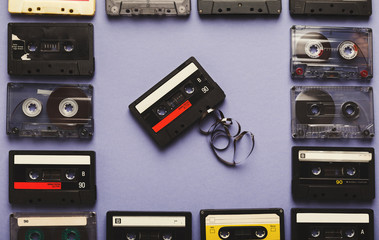 Vintage audio cassettes frame on violet background