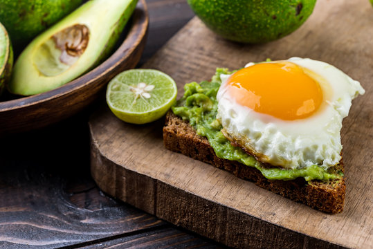 Avocado and egg  toast on a rustic wooden background