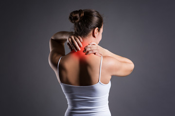 Neck pain, woman with backache on gray background