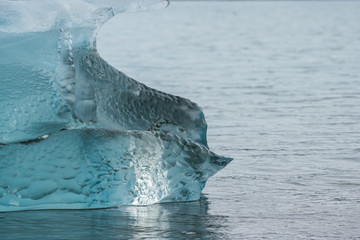 blue clear iceberg in the water at the beach