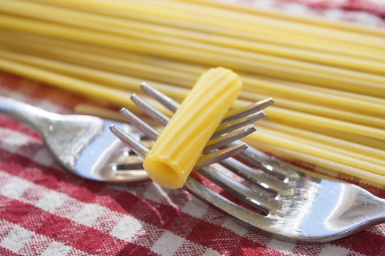 grain of pasta put between two intertwined forks