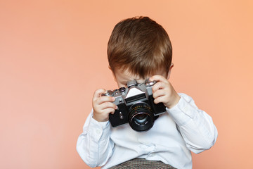 Naklejka premium Little boy with aged retro camera. Child with an old camera