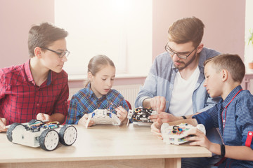 Stem education. Kids creating robots with teacher