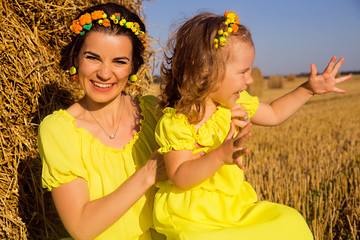 Mom and daughter in yellow dresses are having fun together