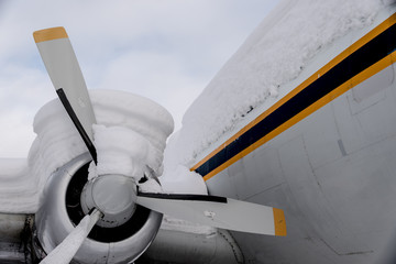 Close-up of snow-covered DC-4 aircraft propeller and engine