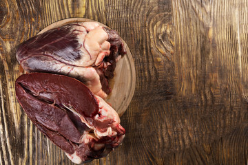 Beef heart on a wooden rustic table. Copy spase