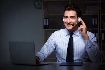 Call center operator talking to customer during night shift 