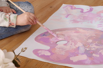 girl paint on lilac palette in the painting studio. happy childhood