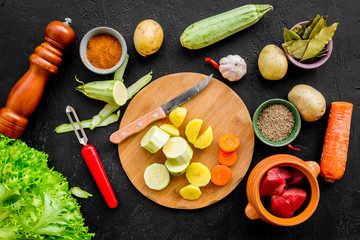 ingredients for vegetable ragout cooking on black table background top view