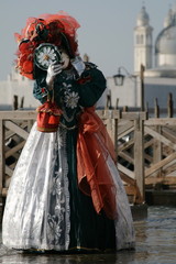  woman in beautiful red green and white masquerade dress and mask at the Venice carnival Italy