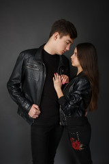 Very stylish and fashionable couple on a gray background in a photo studio
