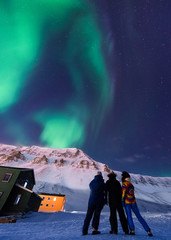 The polar arctic Northern lights aurora borealis sky star in Norway Svalbard in Longyearbyen city man people mountains