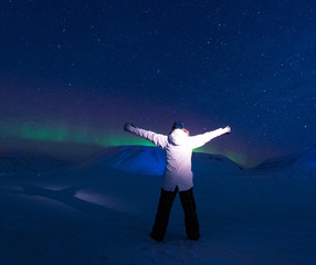 The polar arctic Northern lights aurora borealis sky star in Norway Svalbard in Longyearbyen city man people mountains