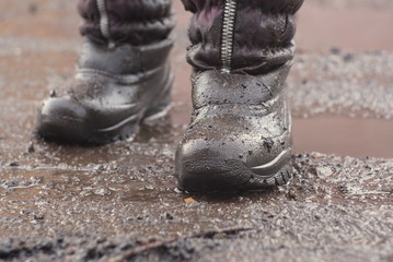 Child boots into a puddle 