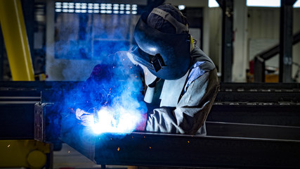 Welding with sparks by Process fluxed cored arc welding , Welding by Welder Thailand , Welder welding steel structure.