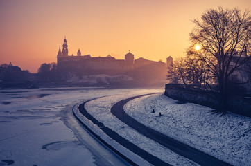 Fototapeta Krakow, Poland, Wawel Castle and Wawel cathedral in the winter over frozen Vistula river, sunrise obraz