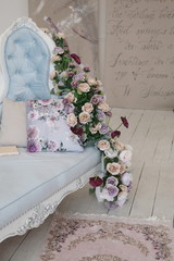 beautiful blue sofa with bouquet of pink and lilac and violet roses
