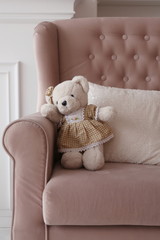 bear toy on the pink sofa in the children room
