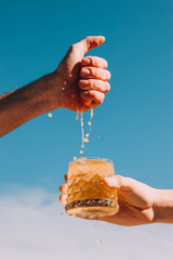 Squeeze out juice from orange by hands into lemonade with ice