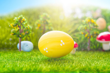 Colorful easter eggs and one big yellow easter egg on spring green grass
