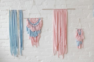 light blue and pink silk ribbons on the white wall in spring decorated room