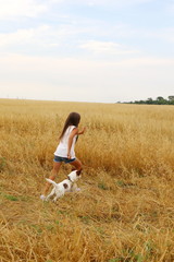 girl running with her dog in the field