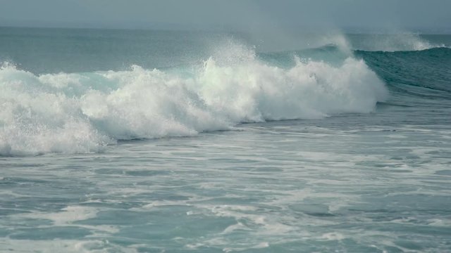 Panning clip of surfer riding a waves blue ocean. Balangan Beach, Bali, Indonesia - January 2018