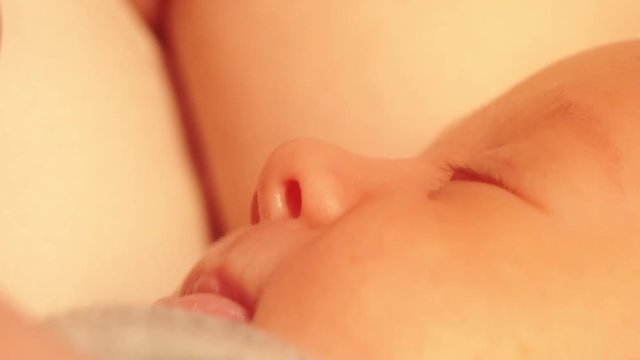 Newborn baby girl sleeping in her mom's hands