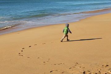 boy walking near the ocean beach
