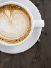 Cup of cappuccino on wooden table.
