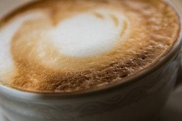Nahaufnahme Milchschaum eines Cappuccino in Tasse auf Tischdecke