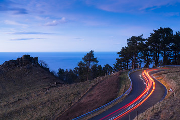 Car lights on the road of Mount Jaizkibel at sunset, Gipuzkoa