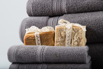 Fototapeta na wymiar grey towels with soaps on the white background.