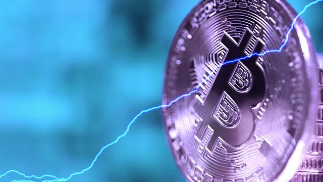 Blockchain technology, bitcoins mining concept with lightnings, macro shot of bitcoins. Cryptocurrency Bitcoin, BTC, power consumption concept